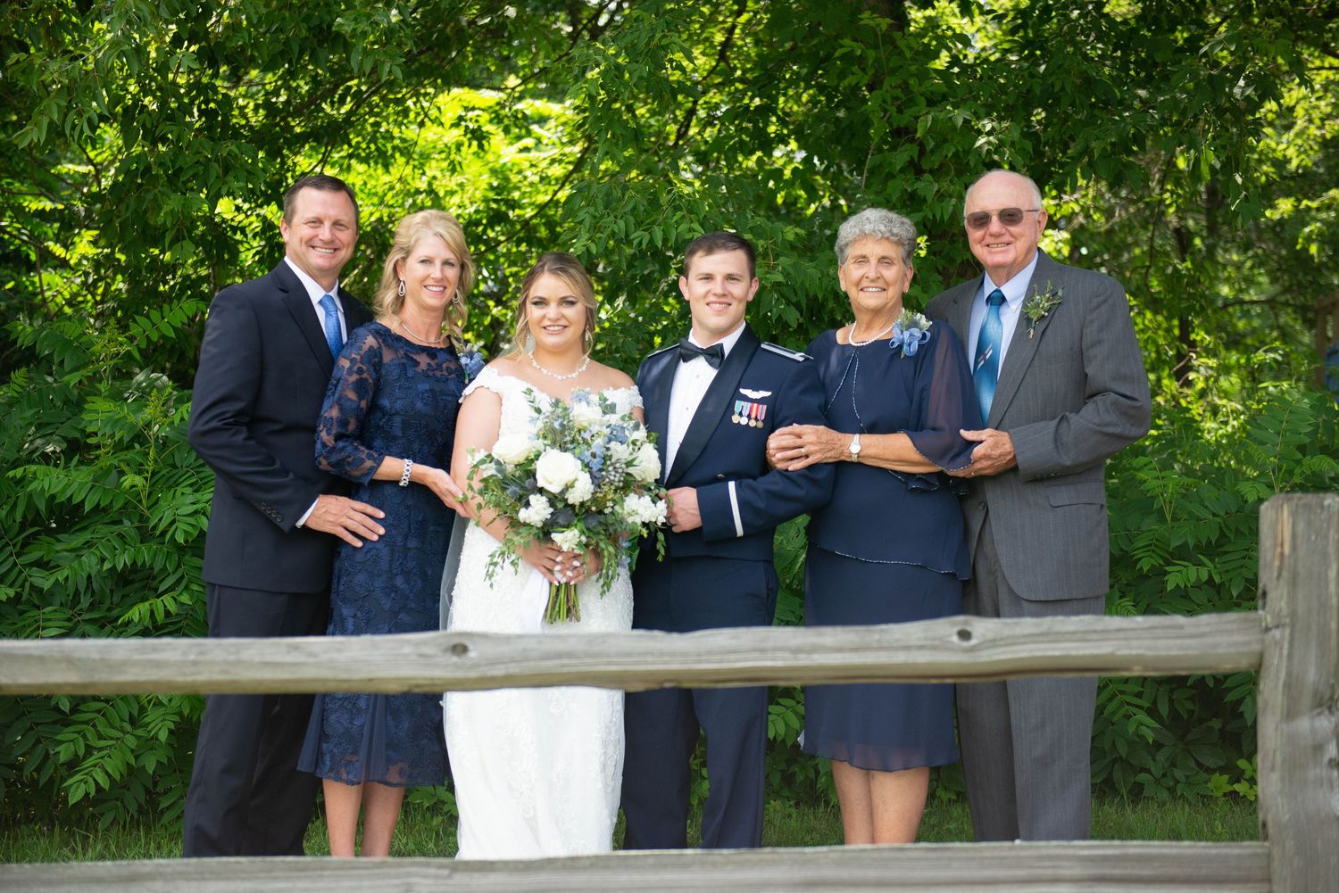 Wedding party poses for group photos in a garden setting. Zimmerman MN Weddings