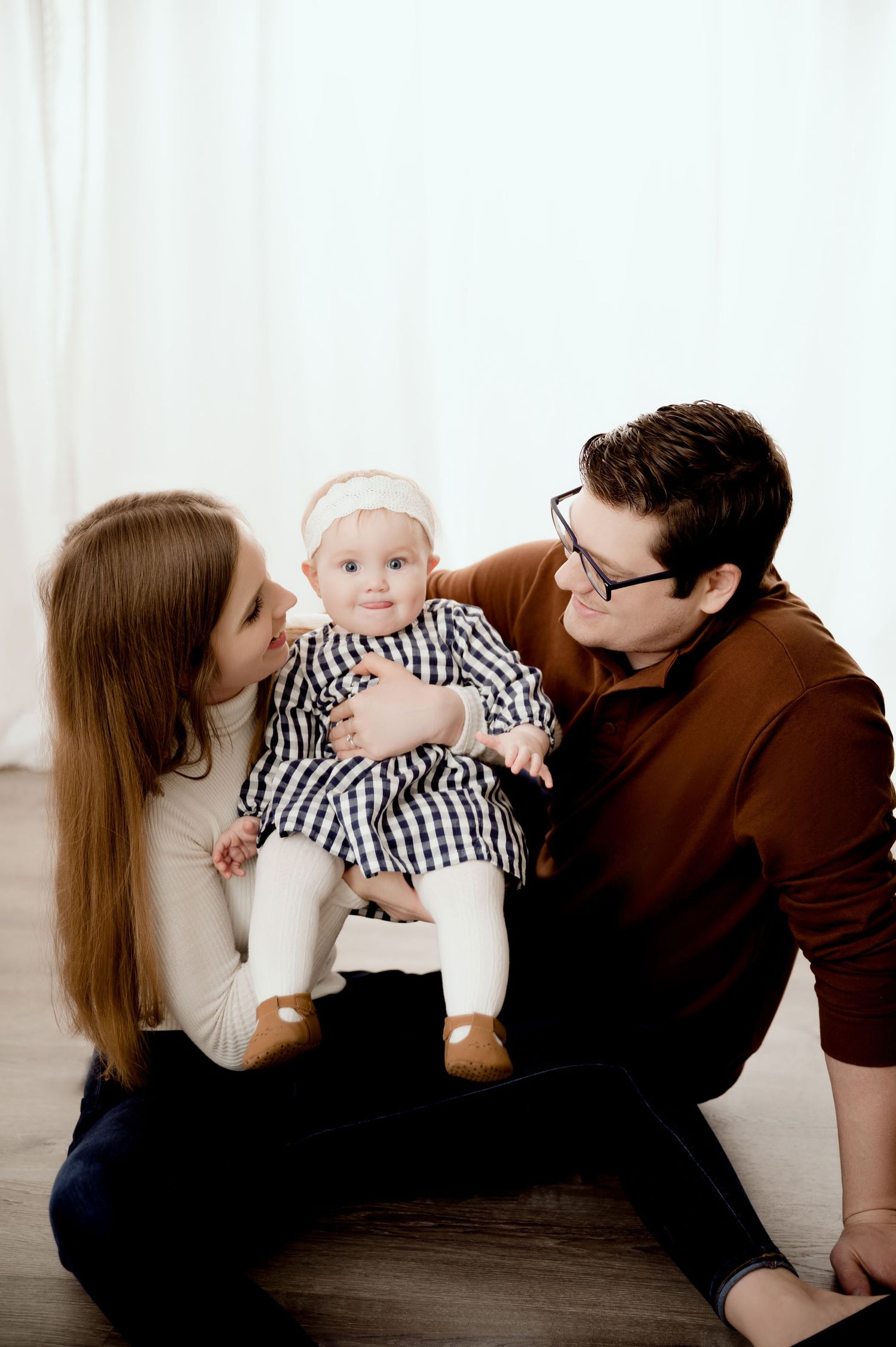 Intimate family portrait against white backdrop.