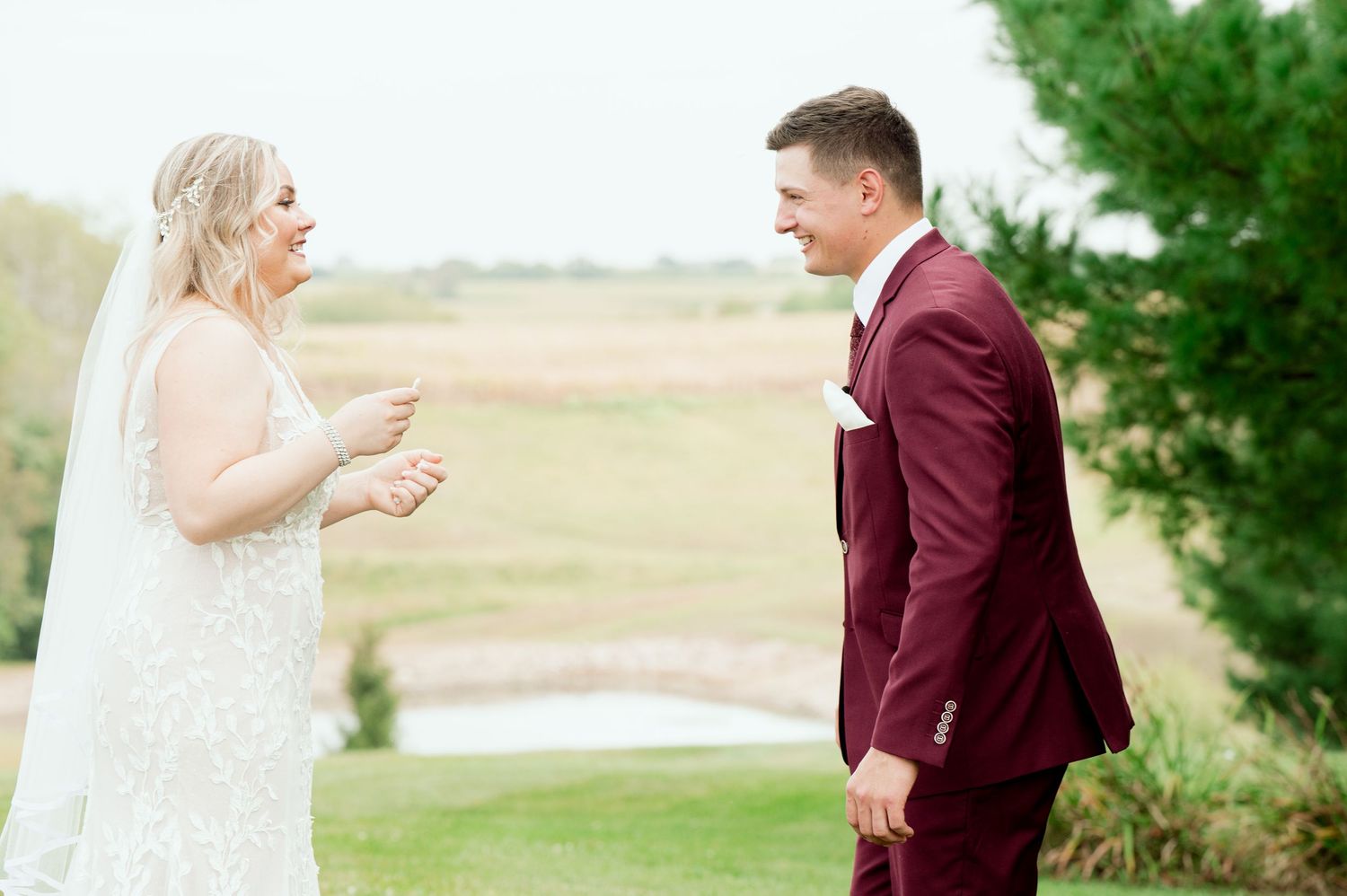 A couple sharing an emotional moment during their outdoor wedding ceremony against a natural backdrop.