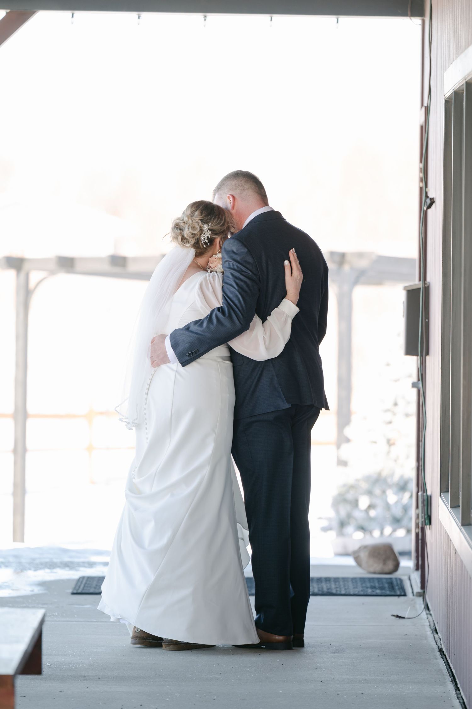 Three romantic wedding couples share intimate moments together on a covered porch in matching formal attire.