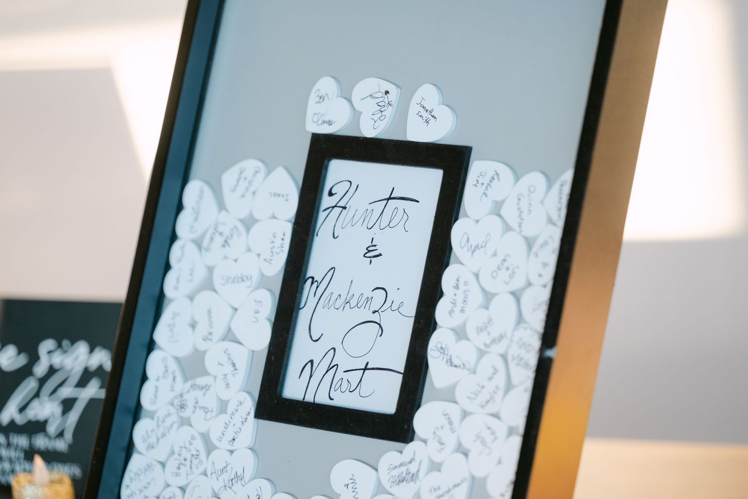 A row of framed artworks displayed on a wall with white paper decorations surrounding them.