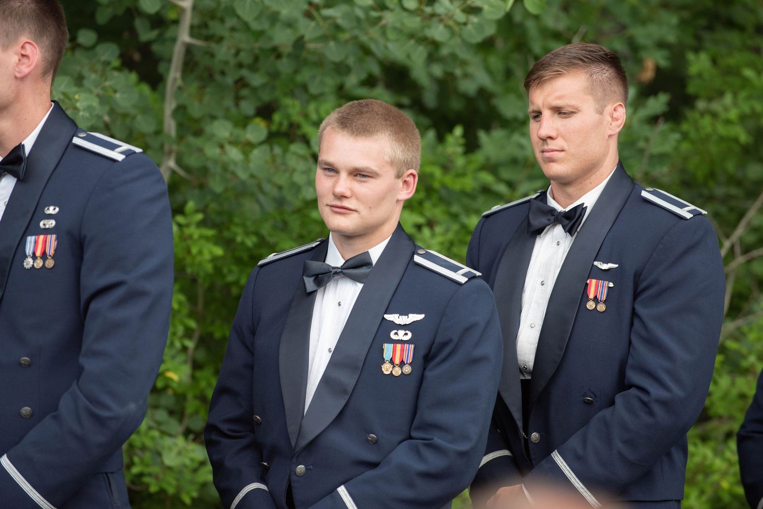 Military groomsmen in formal dress uniforms with medals stand during outdoor wedding ceremony. Zimmerman MN Weddings