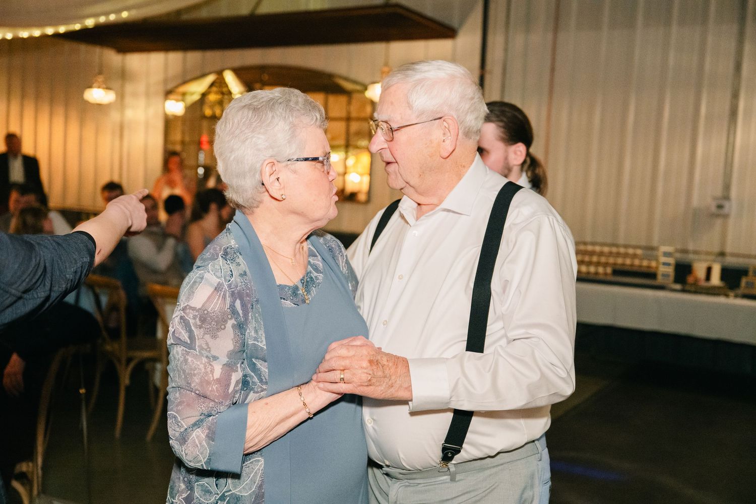 Elderly couple sharing sweet dance moment at wedding reception.