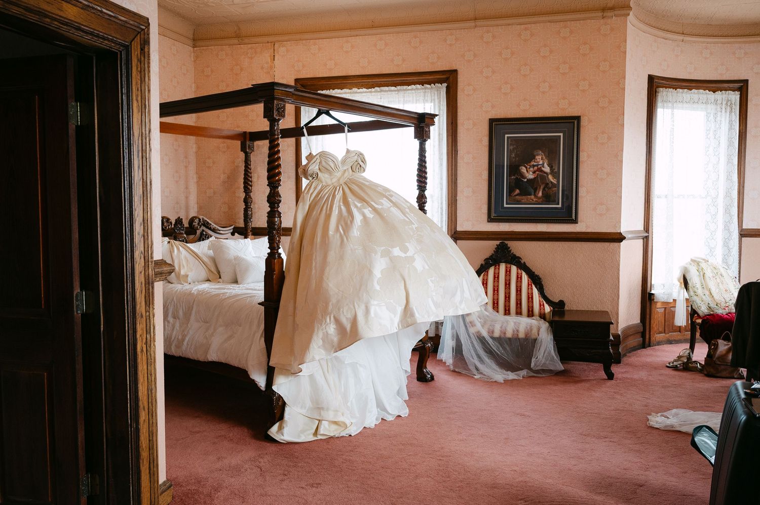 The Historic Concord Exchange Minneapolis MN. Elegant ivory wedding gown draped over a four-poster bed in a vintage-styled bridal suite.