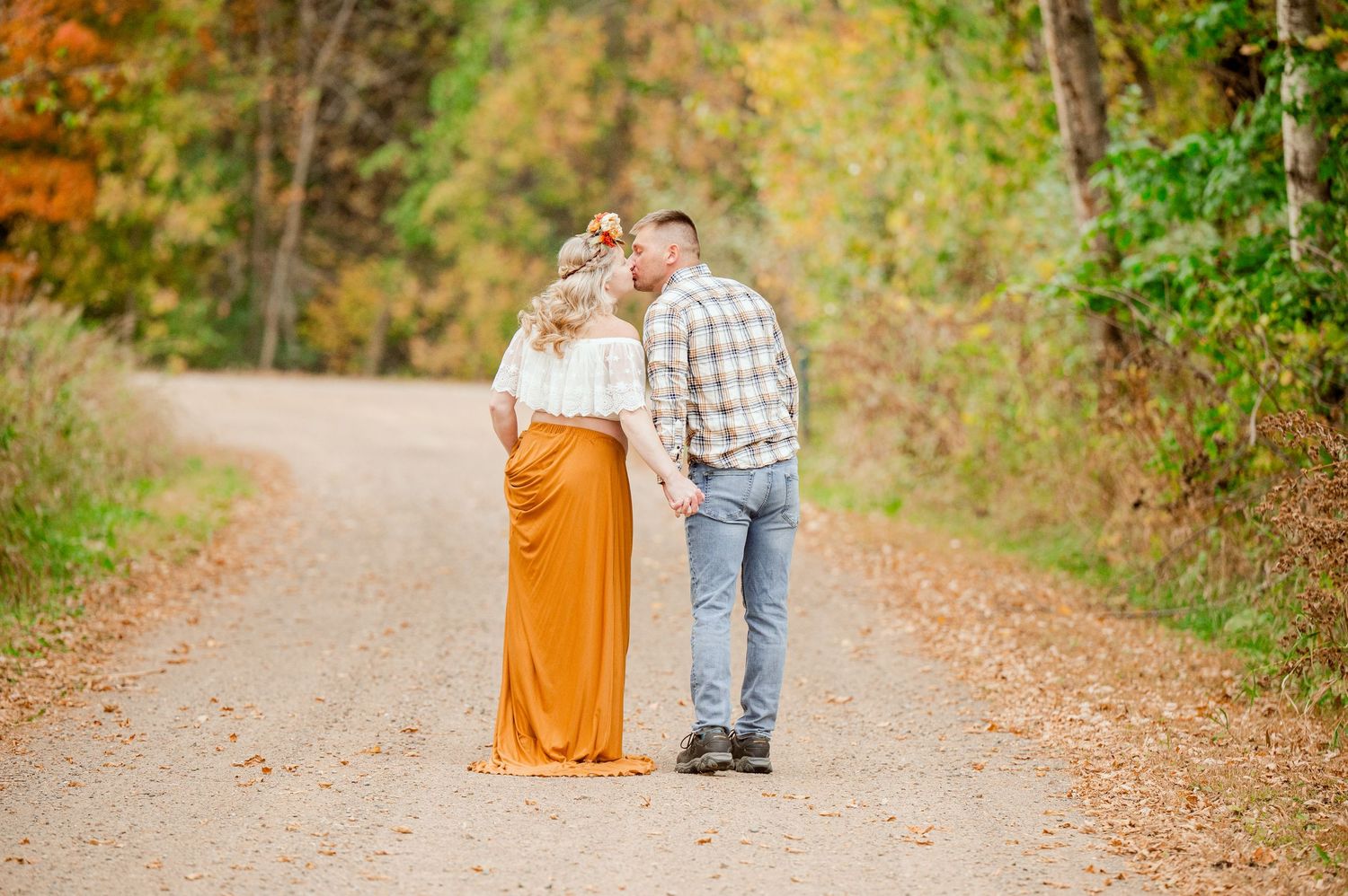 Casual autumn photo session along a path lined with vibrant fall foliage and golden leaves.