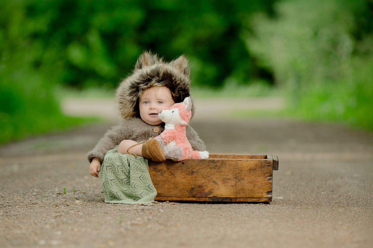 Two people share an intimate moment while sitting next to a rustic wooden box on a dirt path.