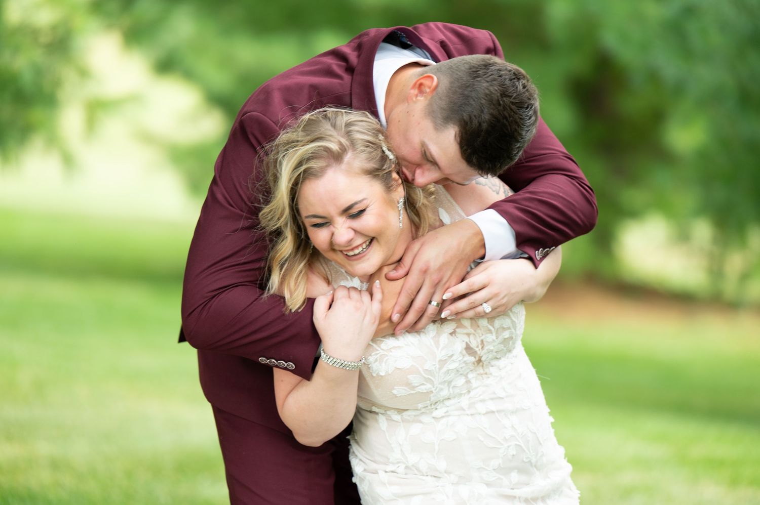 Close-up shots of a couple embracing in burgundy and white wedding attire.