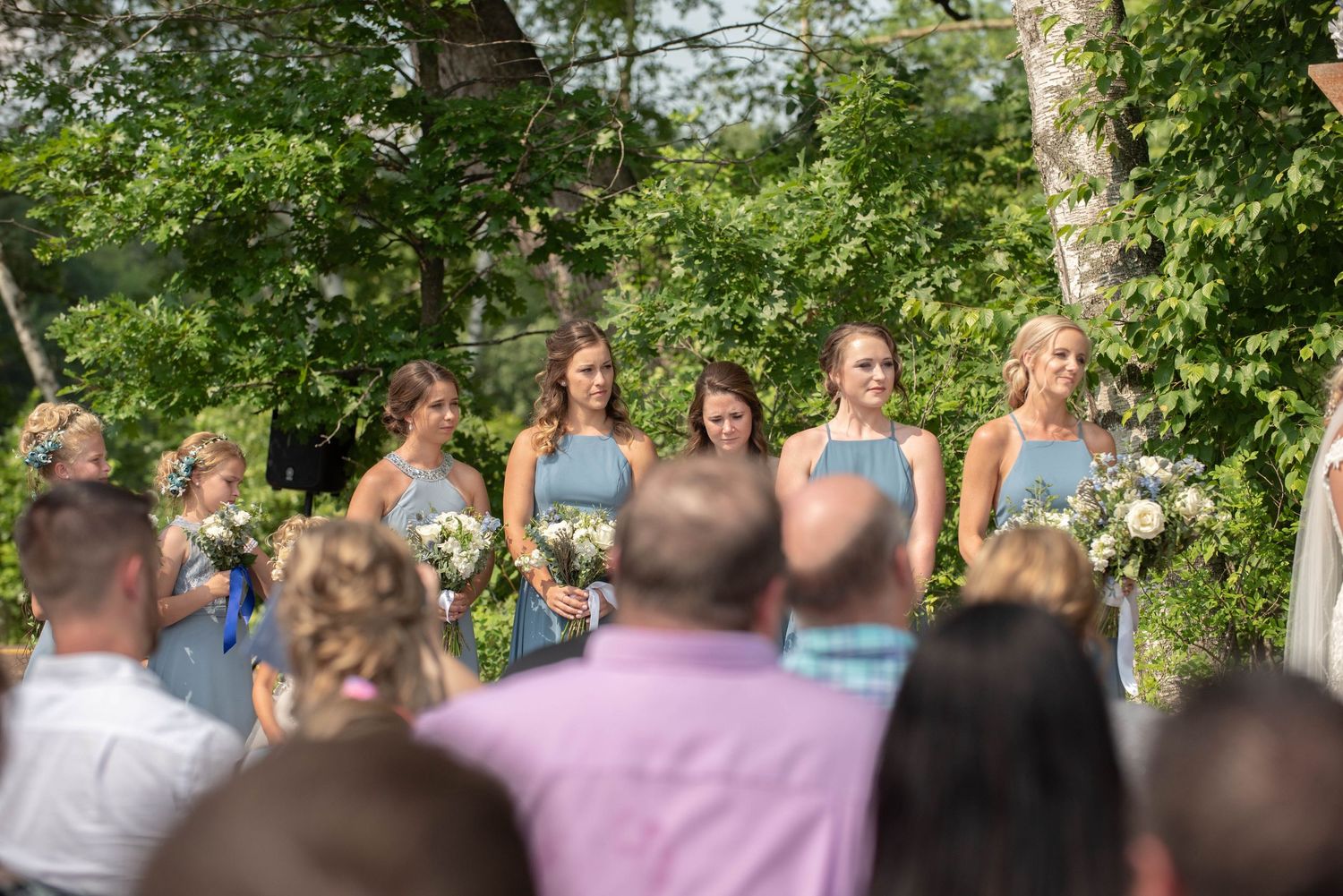 Wedding attendants in mint green dresses stand together during an outdoor ceremony. Zimmerman MN Weddings