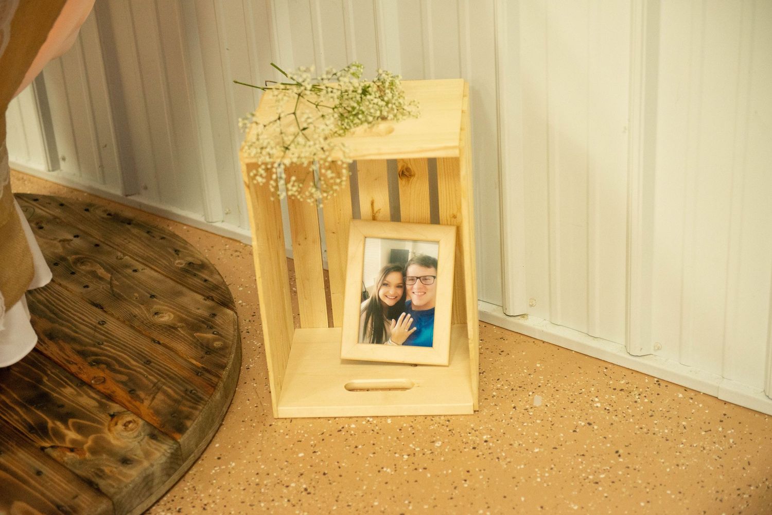 A wooden box display with dried flowers and a framed photograph sits on a decorative surface. Zimmerman MN Weddings