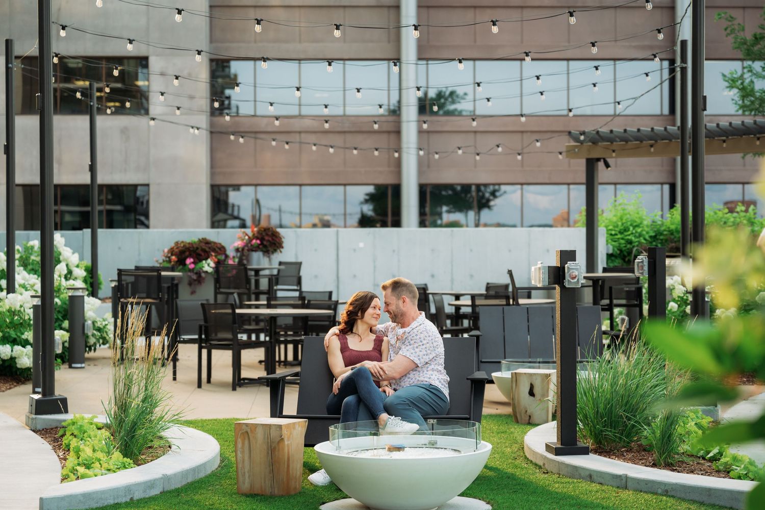 A modern rooftop garden space with string lights and contemporary landscaping features.