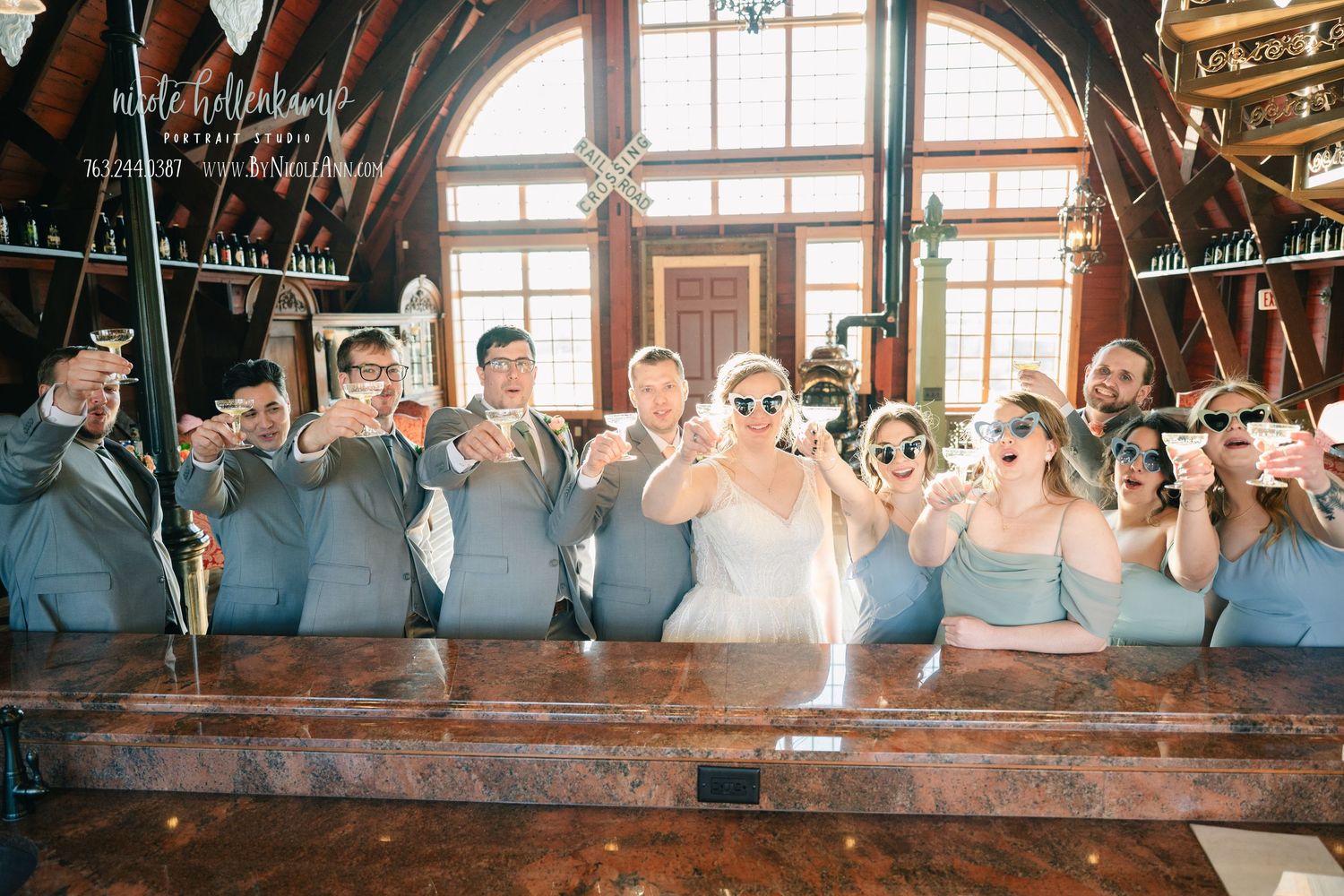 Wedding guests celebrate and dance together on a rustic wooden dance floor during a lively reception celebration.