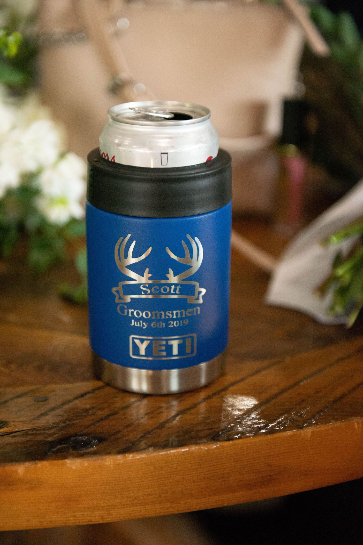 Custom blue Yeti koozies with antler designs displayed as wedding favors on wooden surface. Zimmerman MN Weddings