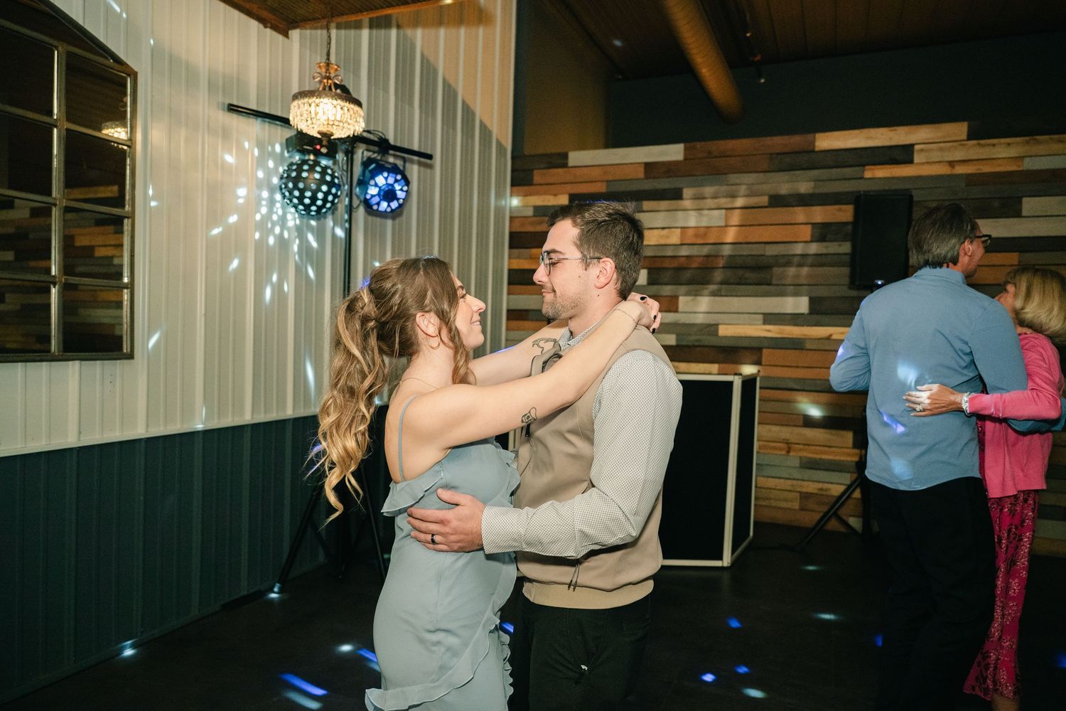 Couple shares a slow dance on the dance floor at their wedding reception.