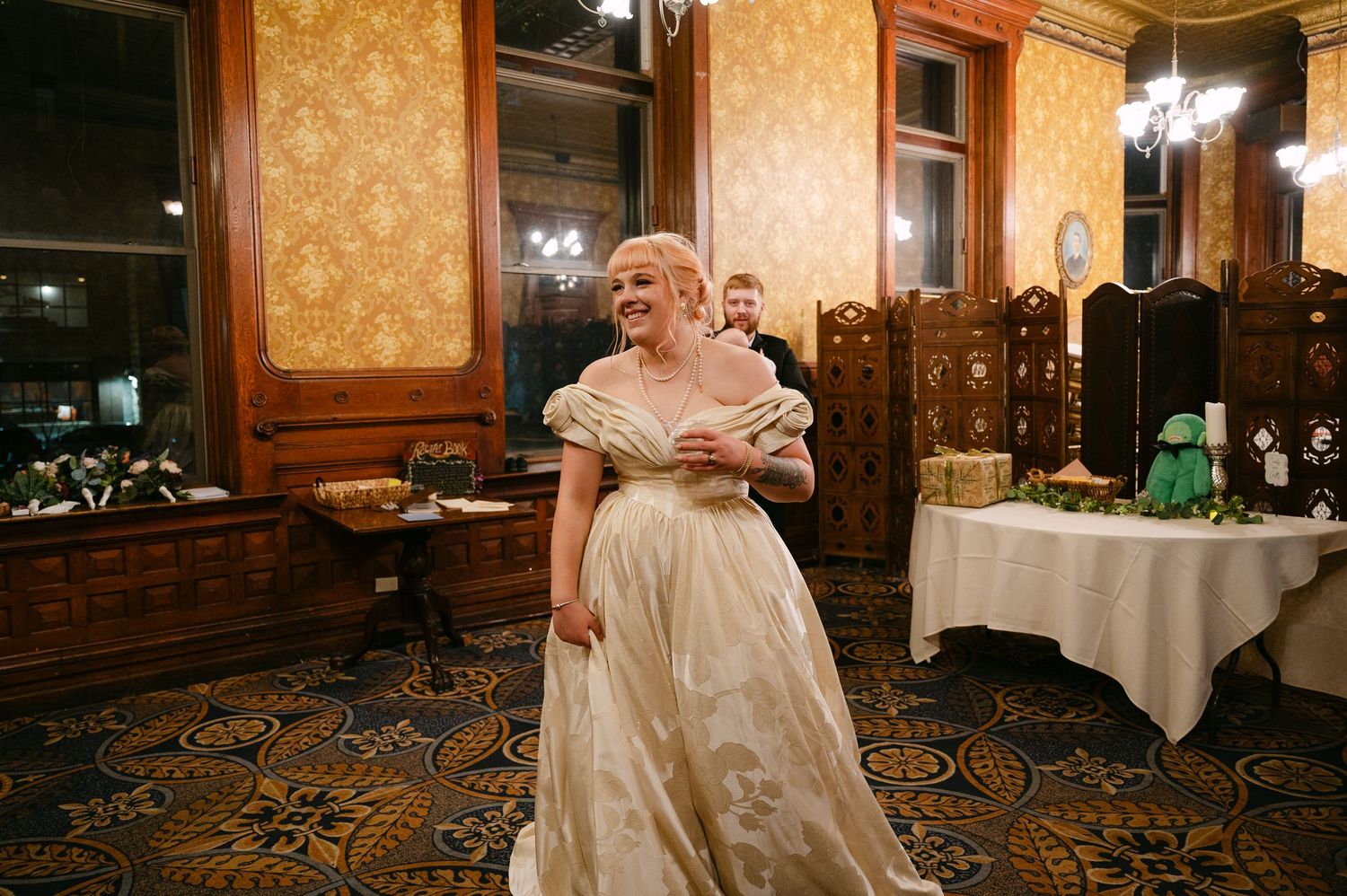 Central MN Wedding Photos | Bride in vintage ivory gown laughs joyfully during elegant wedding reception.