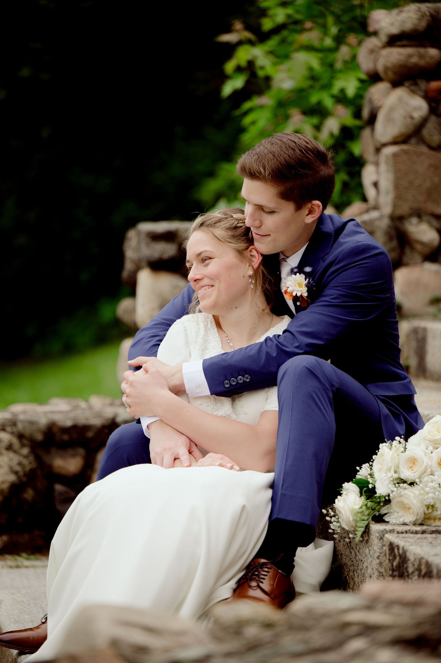Intimate wedding portraits taken on stone steps surrounded by lush greenery.