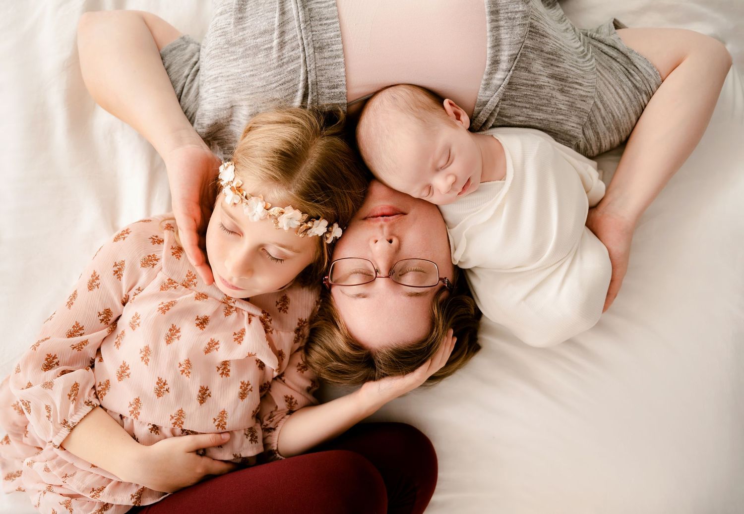 Two people lying together in a casual position wearing pink and white clothing creating a tender moment.