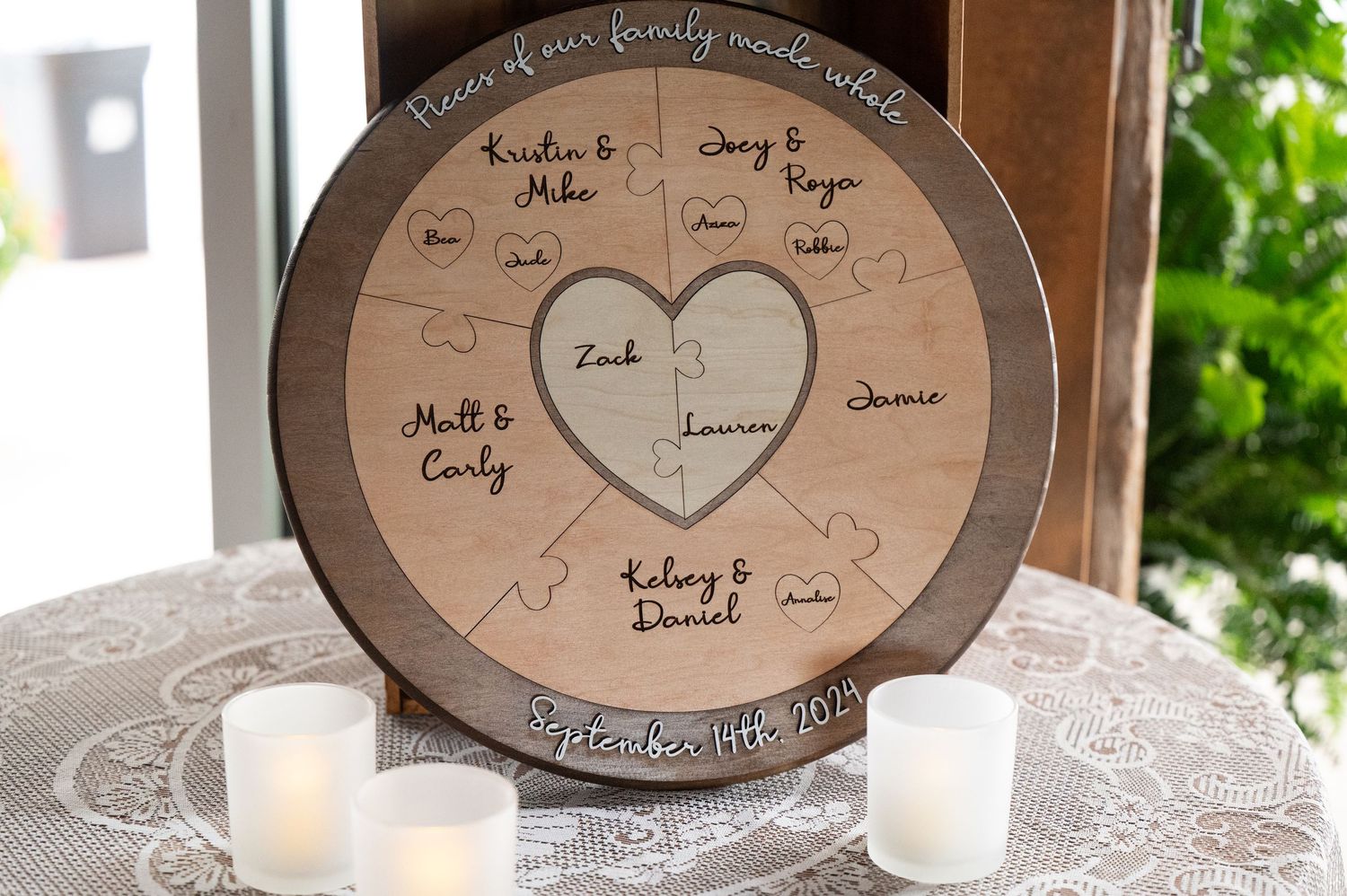 Circular guest seating chart display with handwritten names at wedding reception.