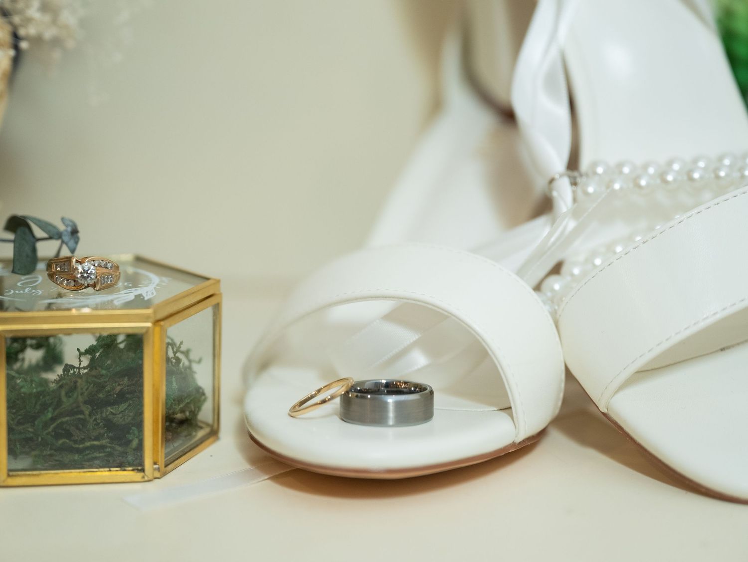 Wedding accessories including white shoes, pearls, and delicate details arranged on a light surface at Northern Lights near Milaca MN..