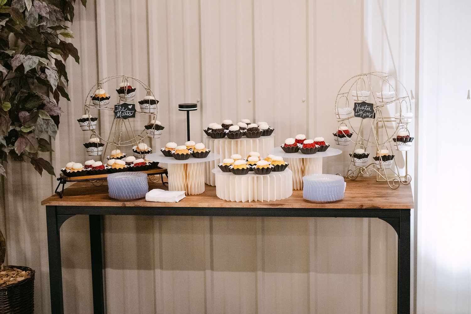 Rustic dessert table display with multiple tiers of treats at wedding reception.