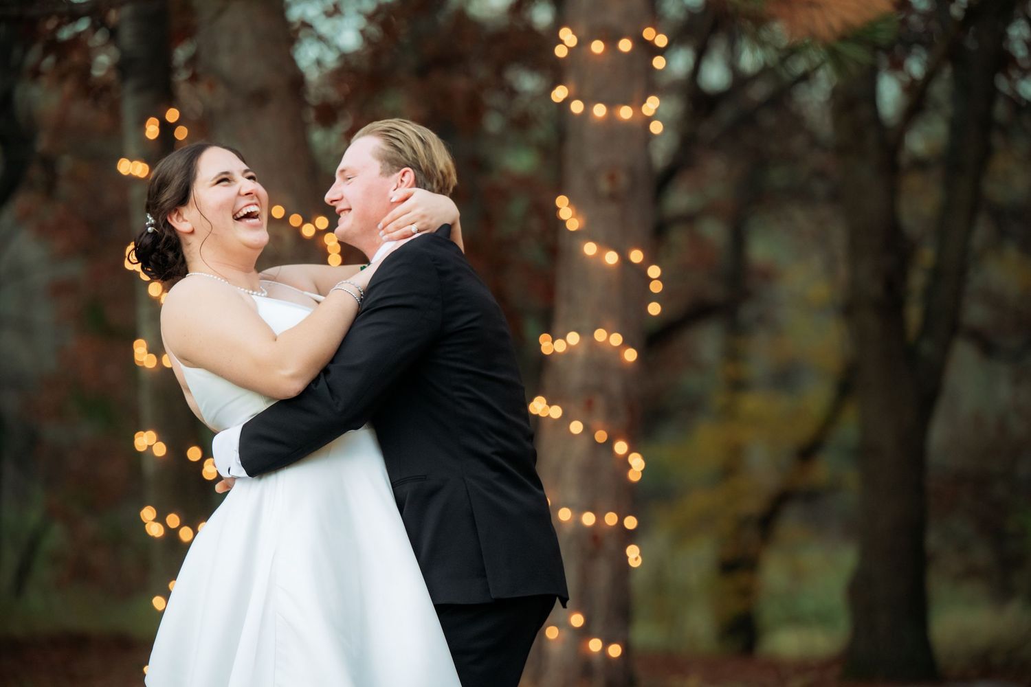 A romantic dance moment with string lights glowing in the background at dusk.