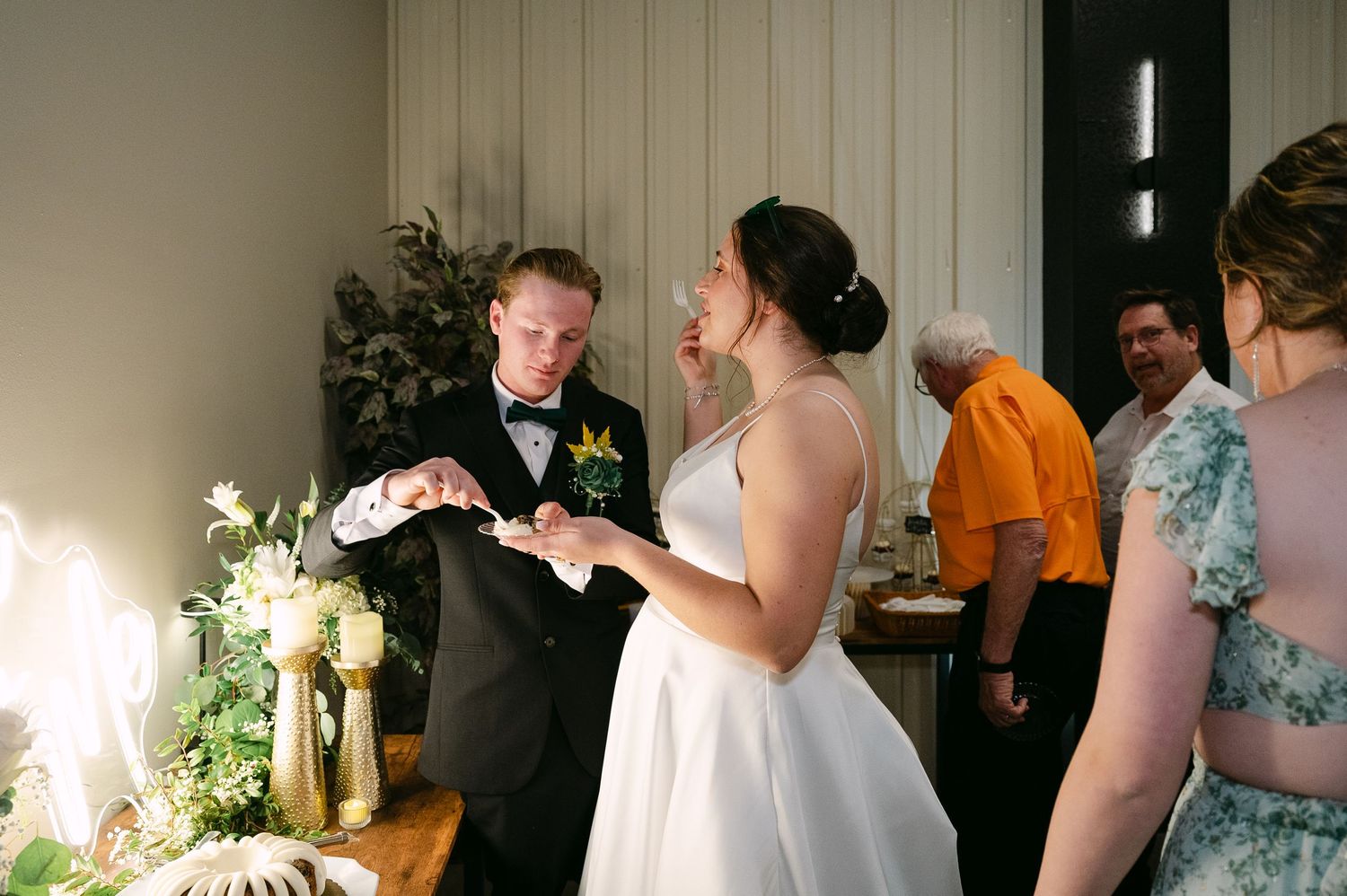 A couple shares their first dance as newlyweds at an indoor wedding reception while guests look on.