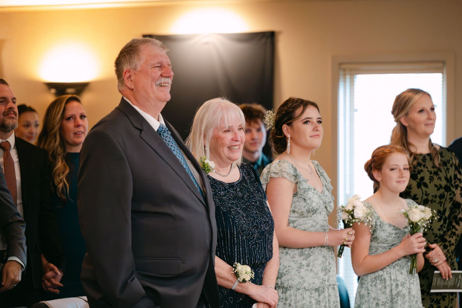 Wedding celebration scene with warm lighting and guests enjoying festivities in a decorated indoor space.