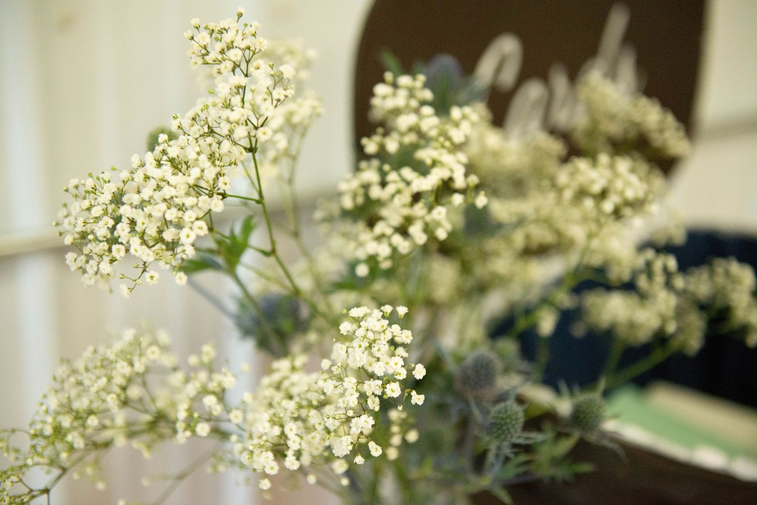 Delicate white flowers and greenery decorating a rustic wedding ceremony space. Zimmerman MN Weddings