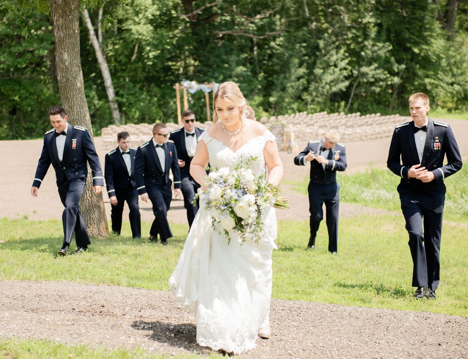 Wedding party following behind on garden path during outdoor ceremony. Zimmerman MN Weddings