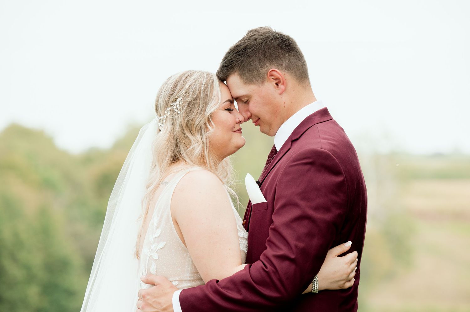 A romantic moment between newlyweds as they embrace outdoors on their wedding day.