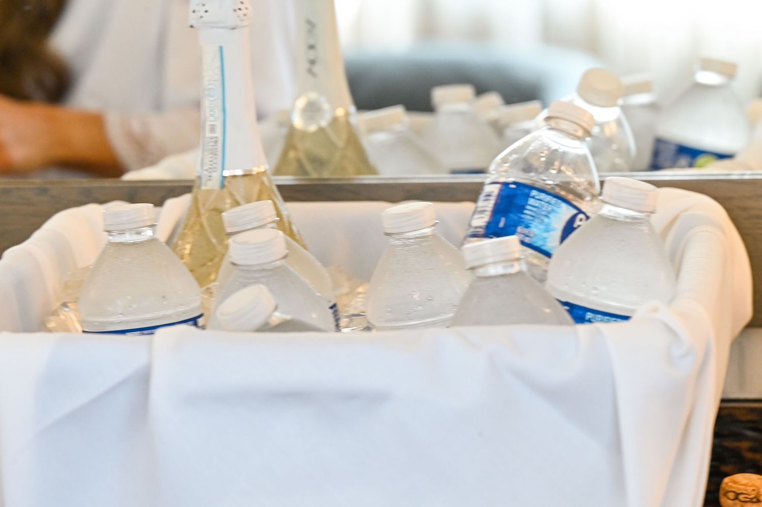 White gift bags arranged on a table at a business or social event.