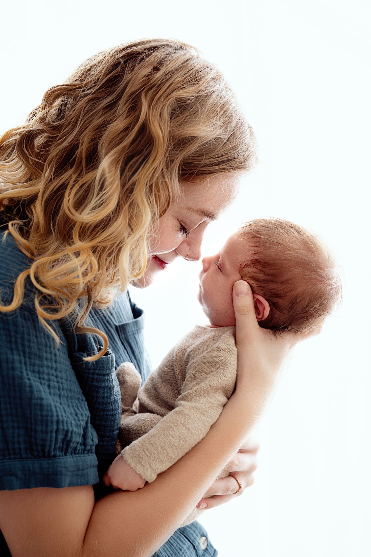 Minnesota Best newborn photographer - Parent and newborn share a tender moment in series of touching close-up portraits. St Cloud MN Area