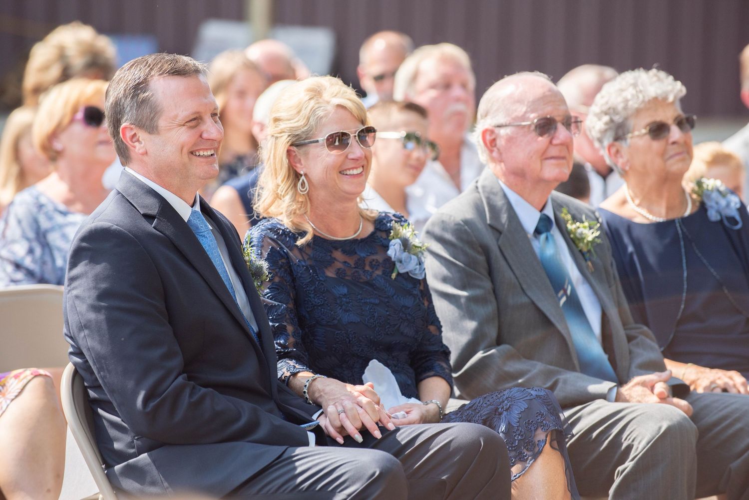 Wedding guests seated outdoors watching the ceremony on a sunny day. Zimmerman MN Weddings