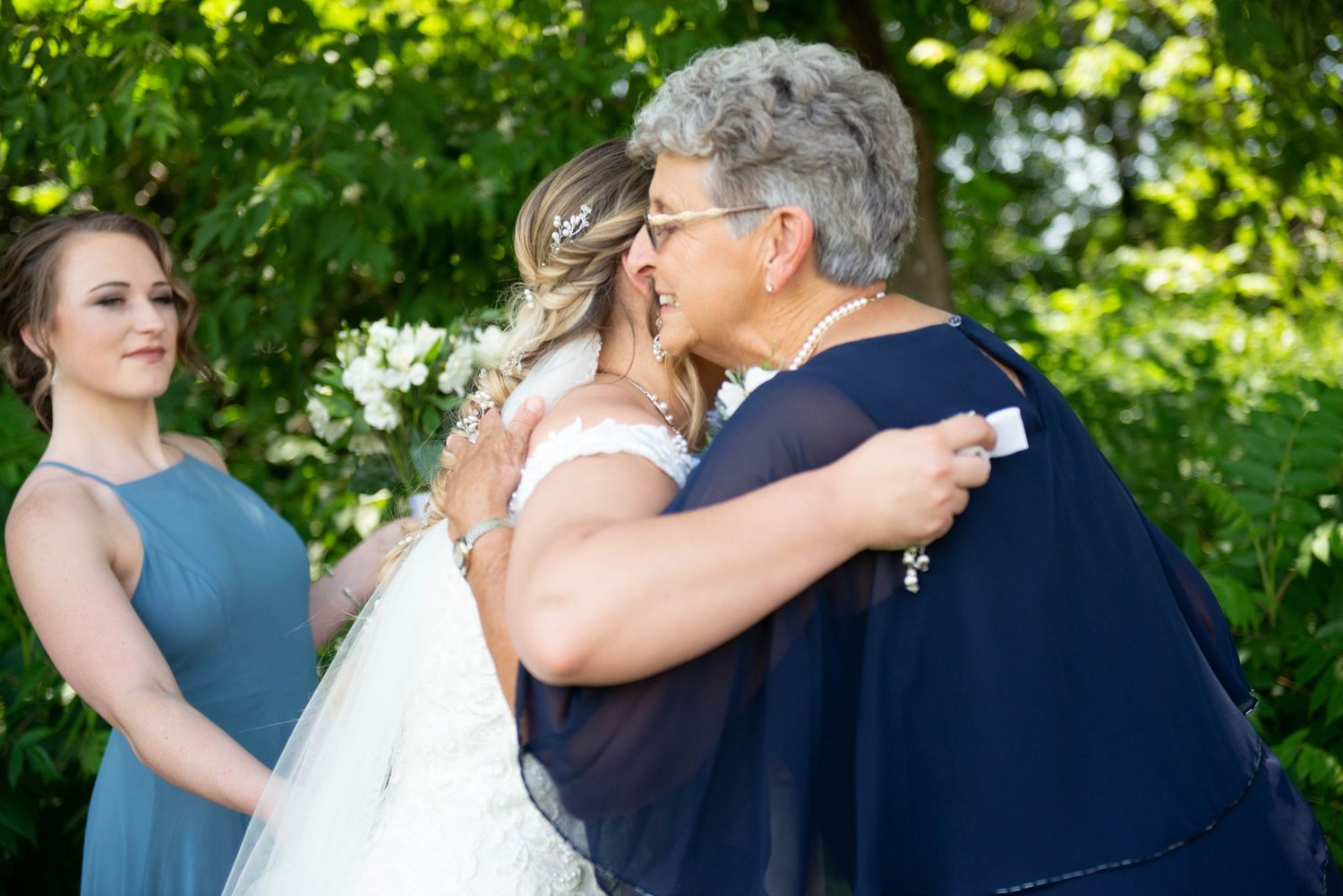 Wedding party members embrace and celebrate outdoors. Zimmerman MN Weddings