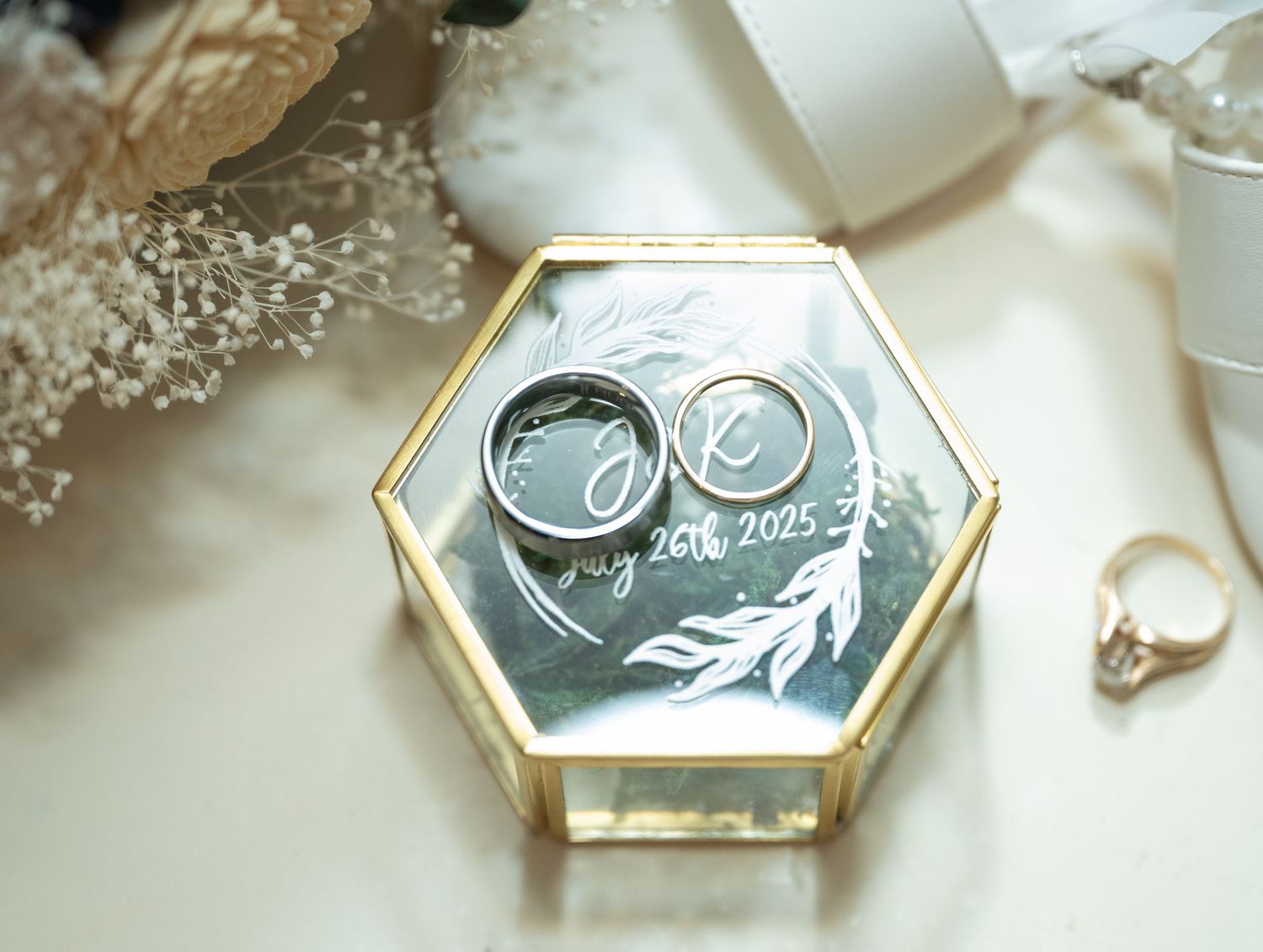 Hexagonal silver and gold pendants with delicate leaf designs arranged in a row on a white surface at Northern Lights near Milaca MN..
