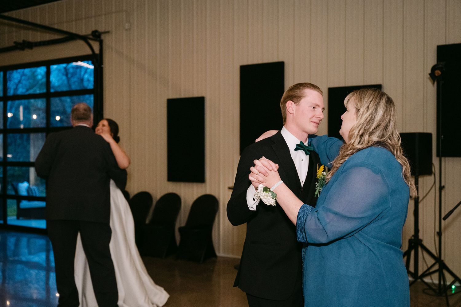 Wedding reception dance floor scene with elegant formal attire and indoor venue lighting.