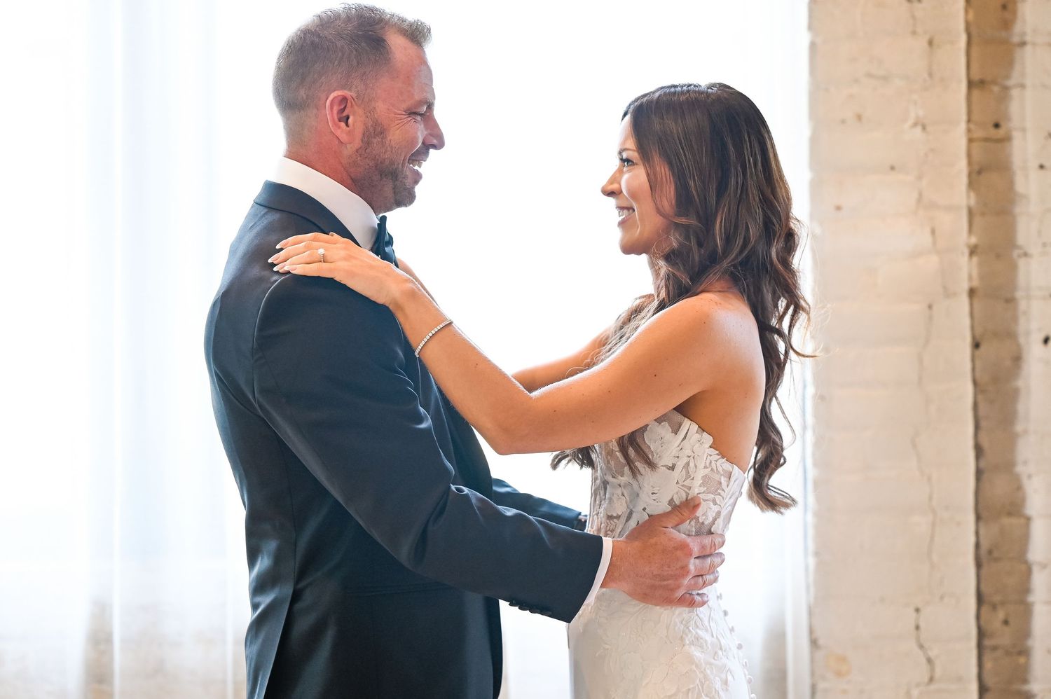 A tender moment shared between a couple in formal wedding attire.