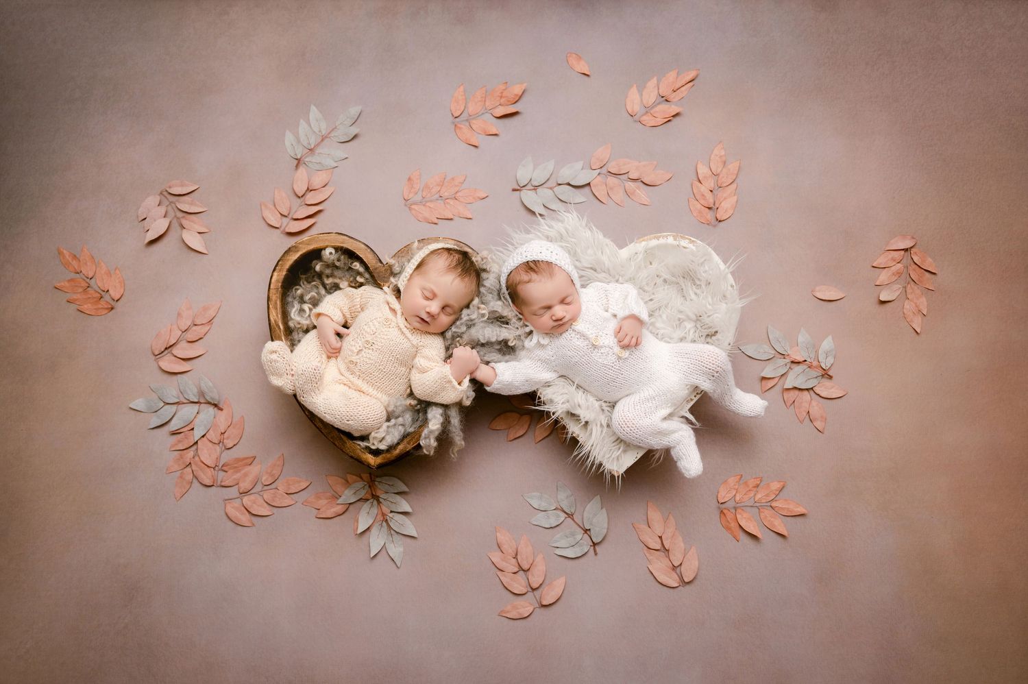 Central MN Baby Photos - Two newborn twins posed with autumn leaves, one in a basket and one on a fluffy white rug, wearing cream outfits.