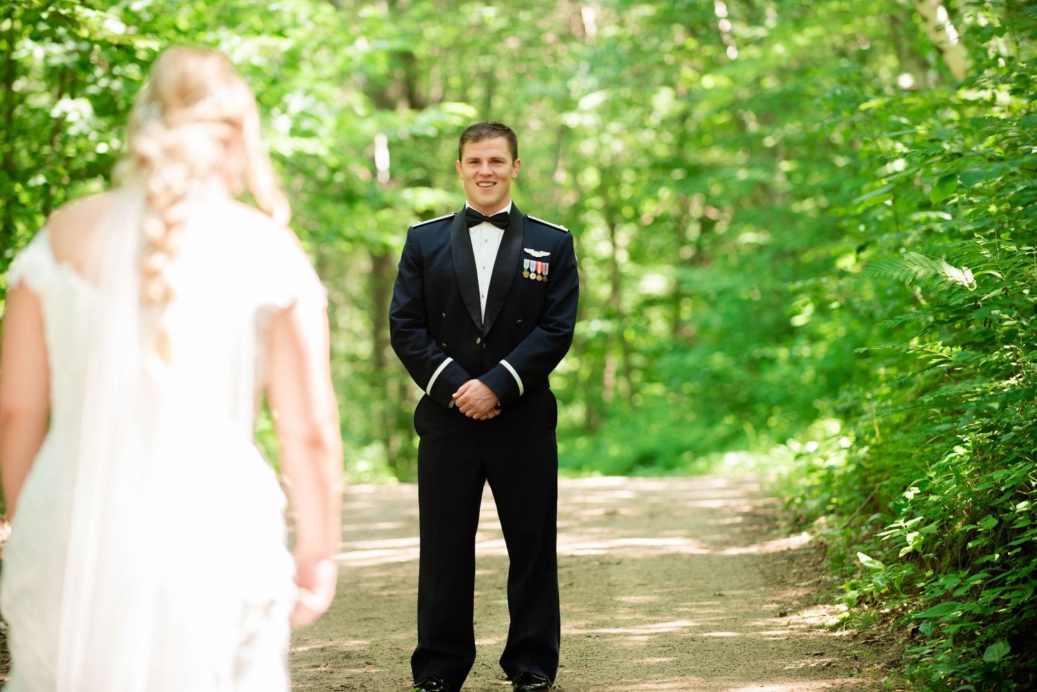 Wedding party walking along a tree-lined pathway in formal attire. Zimmerman MN Weddings