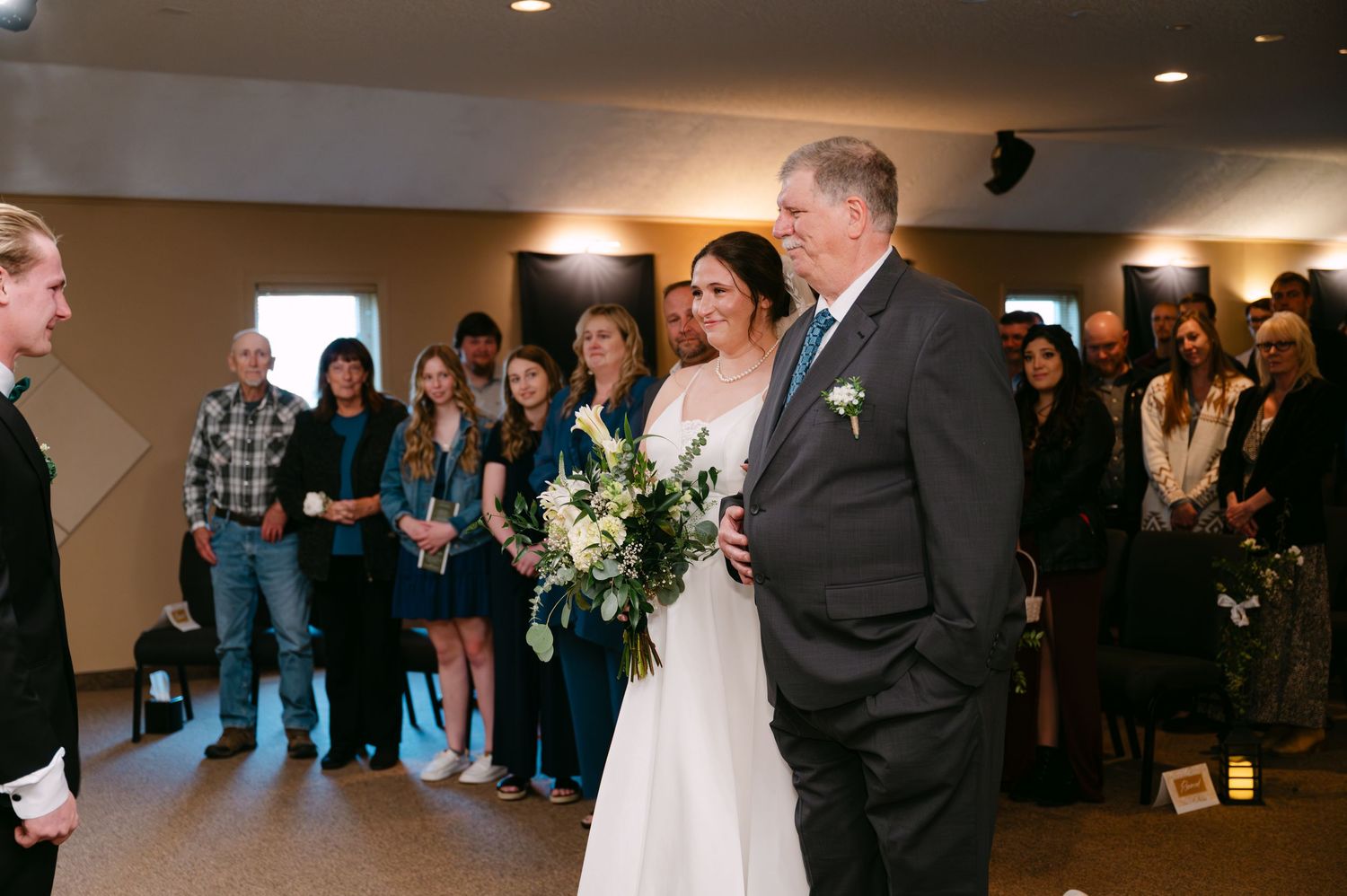 Wedding guests and attendees gathered in an indoor venue for a ceremony.