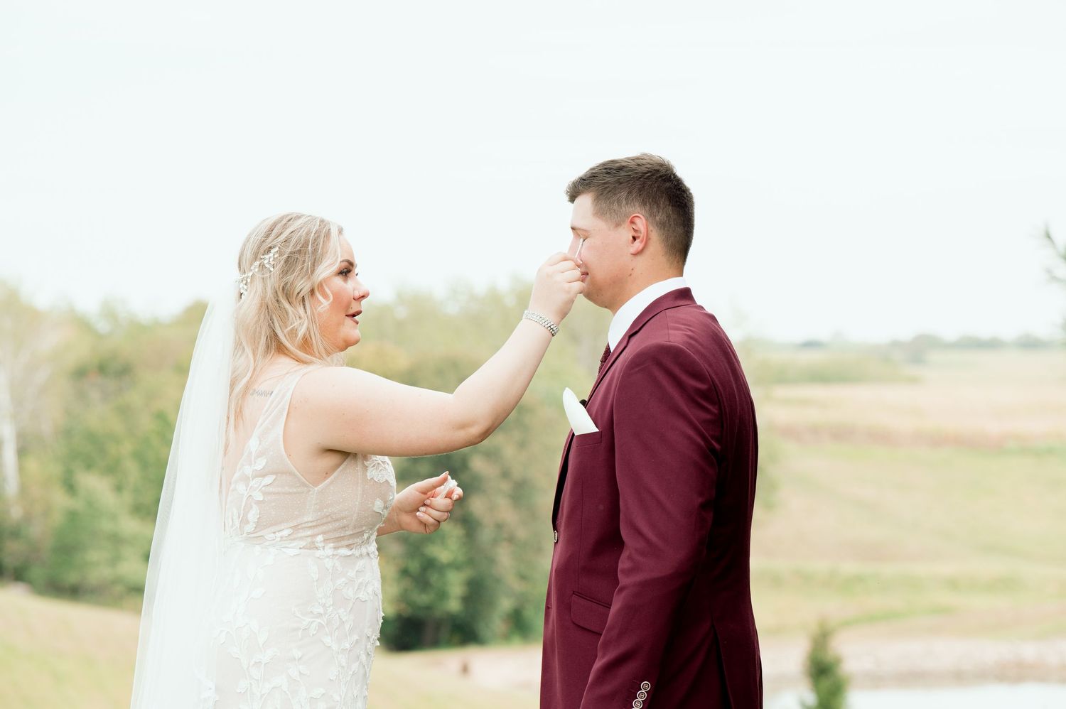 An emotional moment captured during a wedding first look on a scenic hillside.