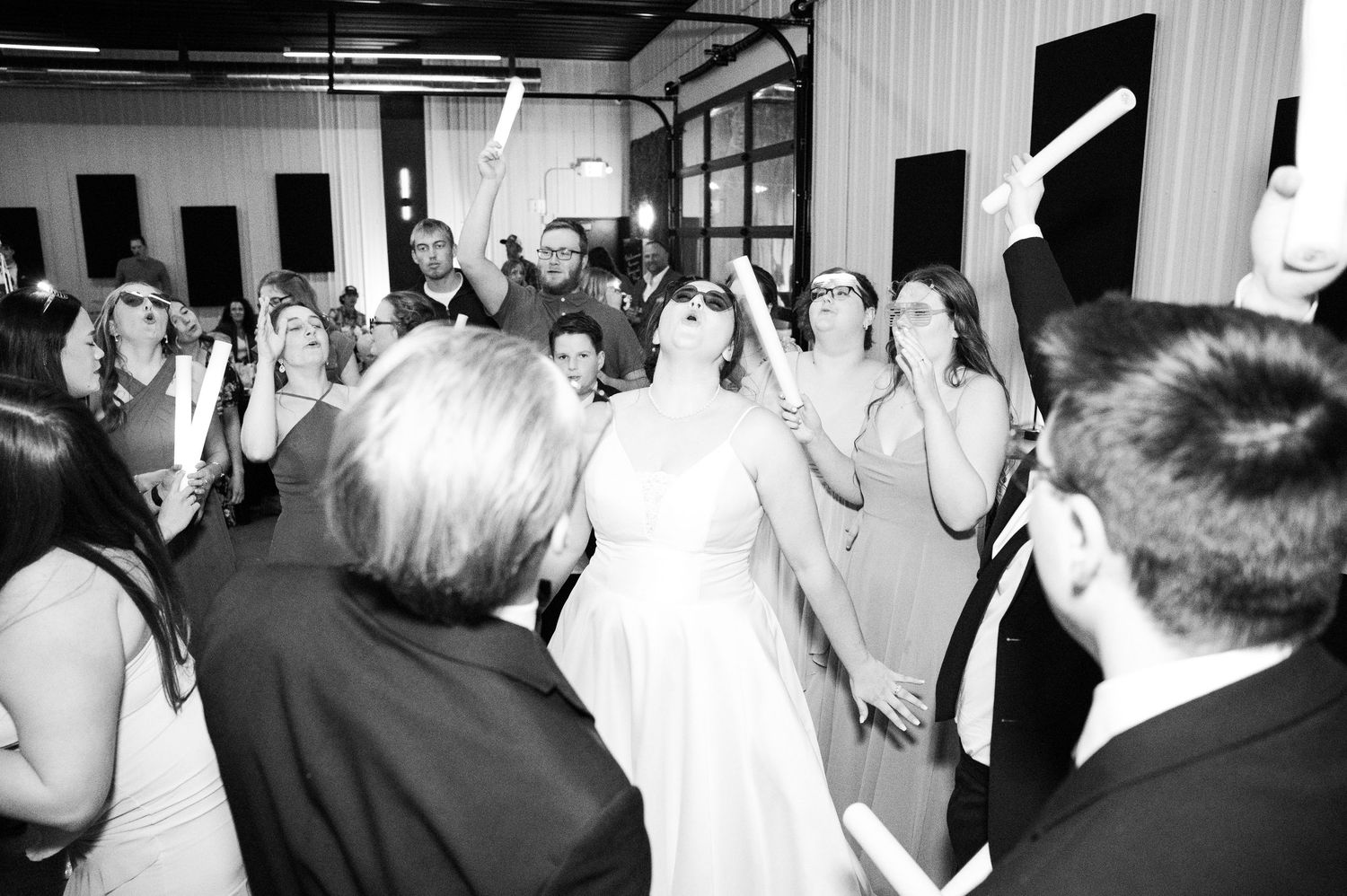 Black and white photo of wedding reception guests dancing and celebrating on a crowded dance floor at Heart and Soul Chapel Princeton MN..