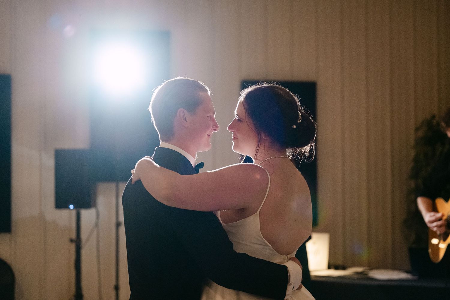 In central Minnesota a couple shares a tender dance moment in a dimly lit reception venue.