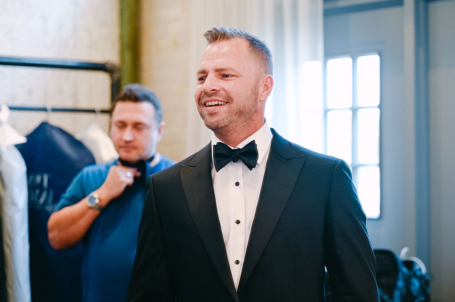 Emotional first look moment between newlyweds in a bright indoor venue with brick walls.