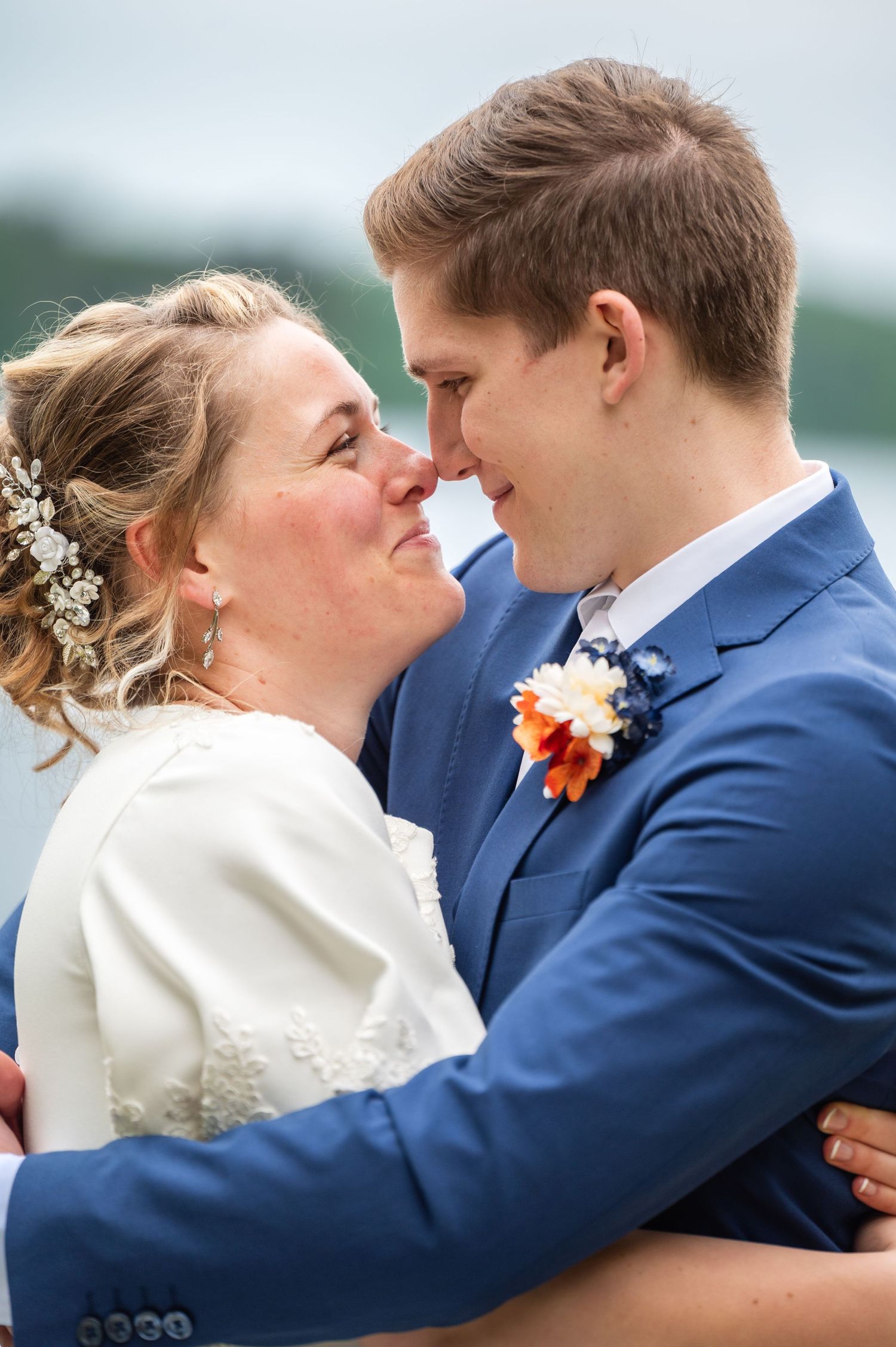 A series of tender wedding photos captures newlyweds embracing in navy and white attire.