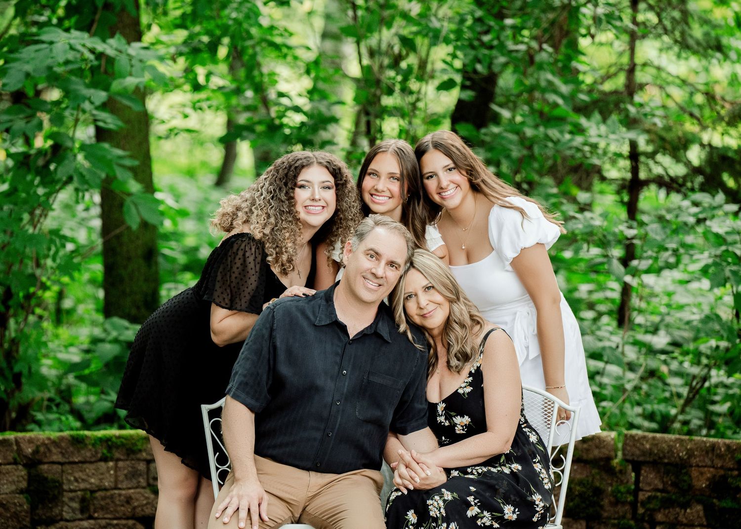 Group photo session in lush forest setting with coordinated outfits.
