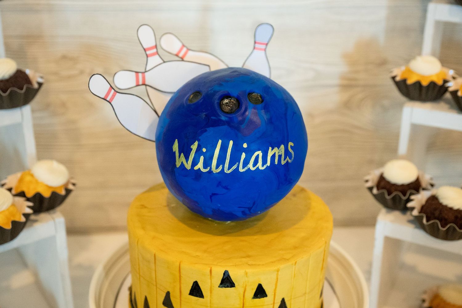 Wedding cake topper featuring a blue bowling ball engraved with Williams and decorative bowling pins.