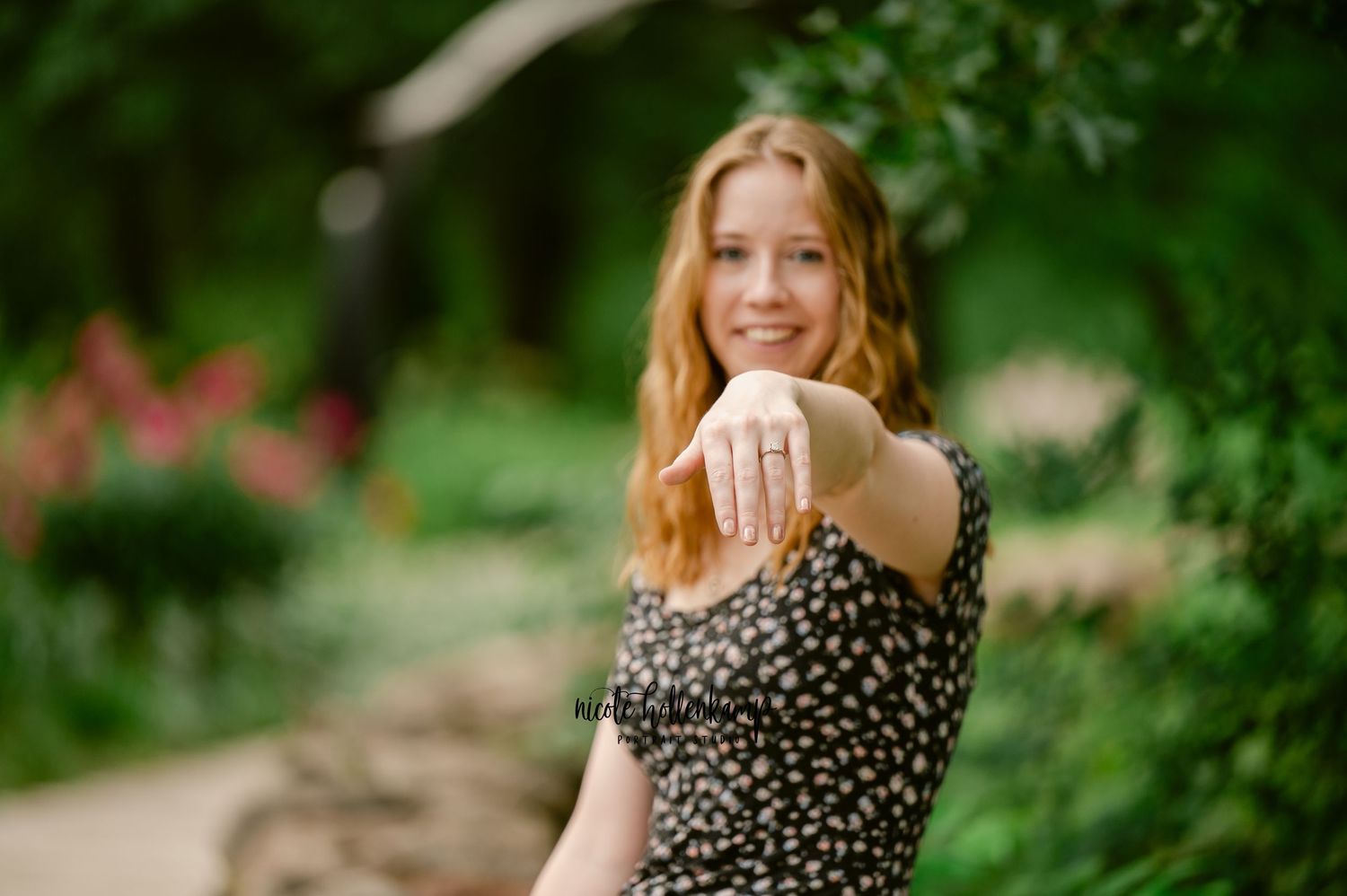 Someone in a floral dress poses in a lush garden setting during golden hour photography session.