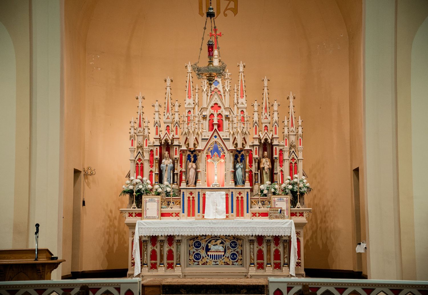 Ornate traditional Catholic church altar with multiple tiers of candles and religious decorations.