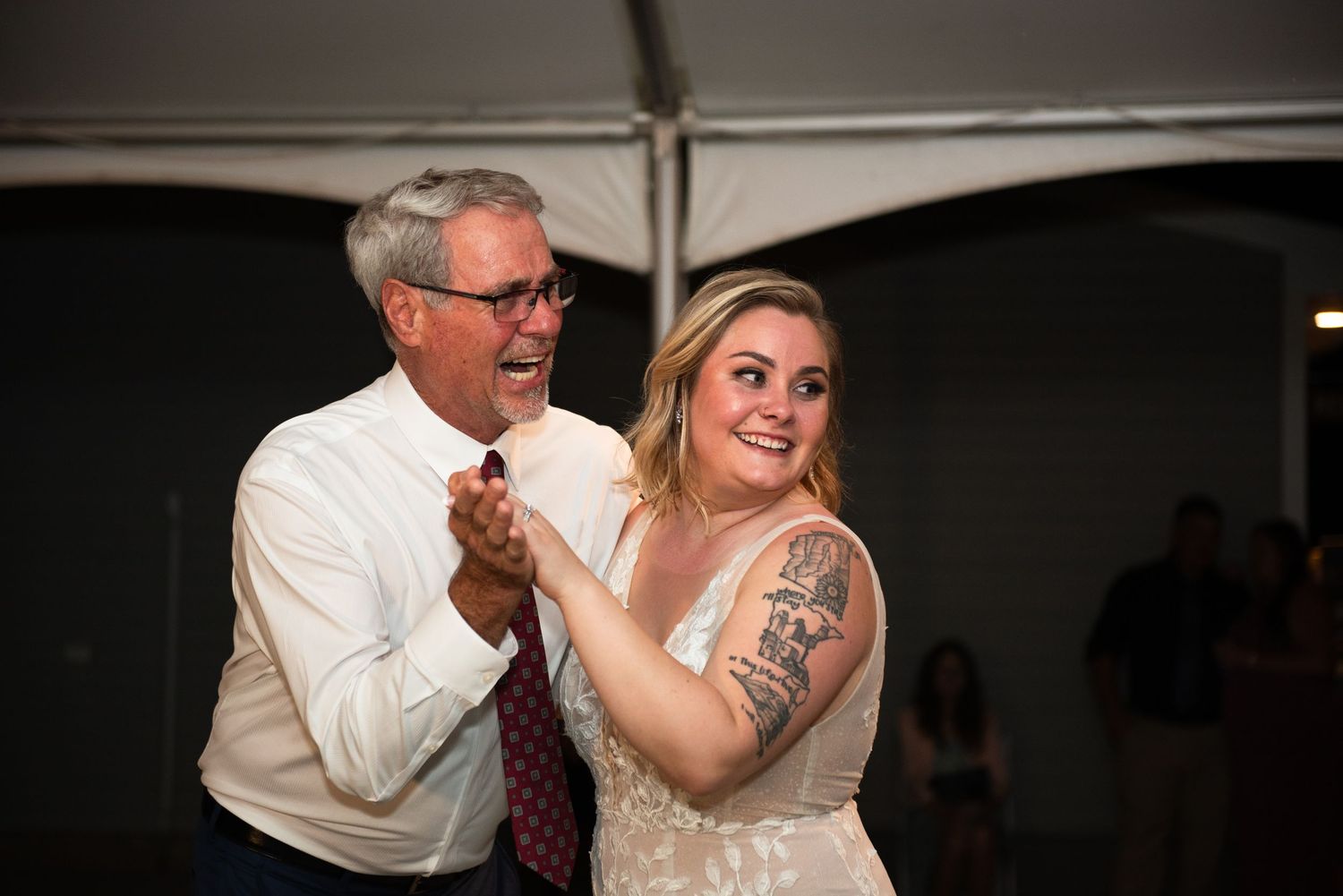 Couples slow dancing together under soft lighting at an evening wedding reception.