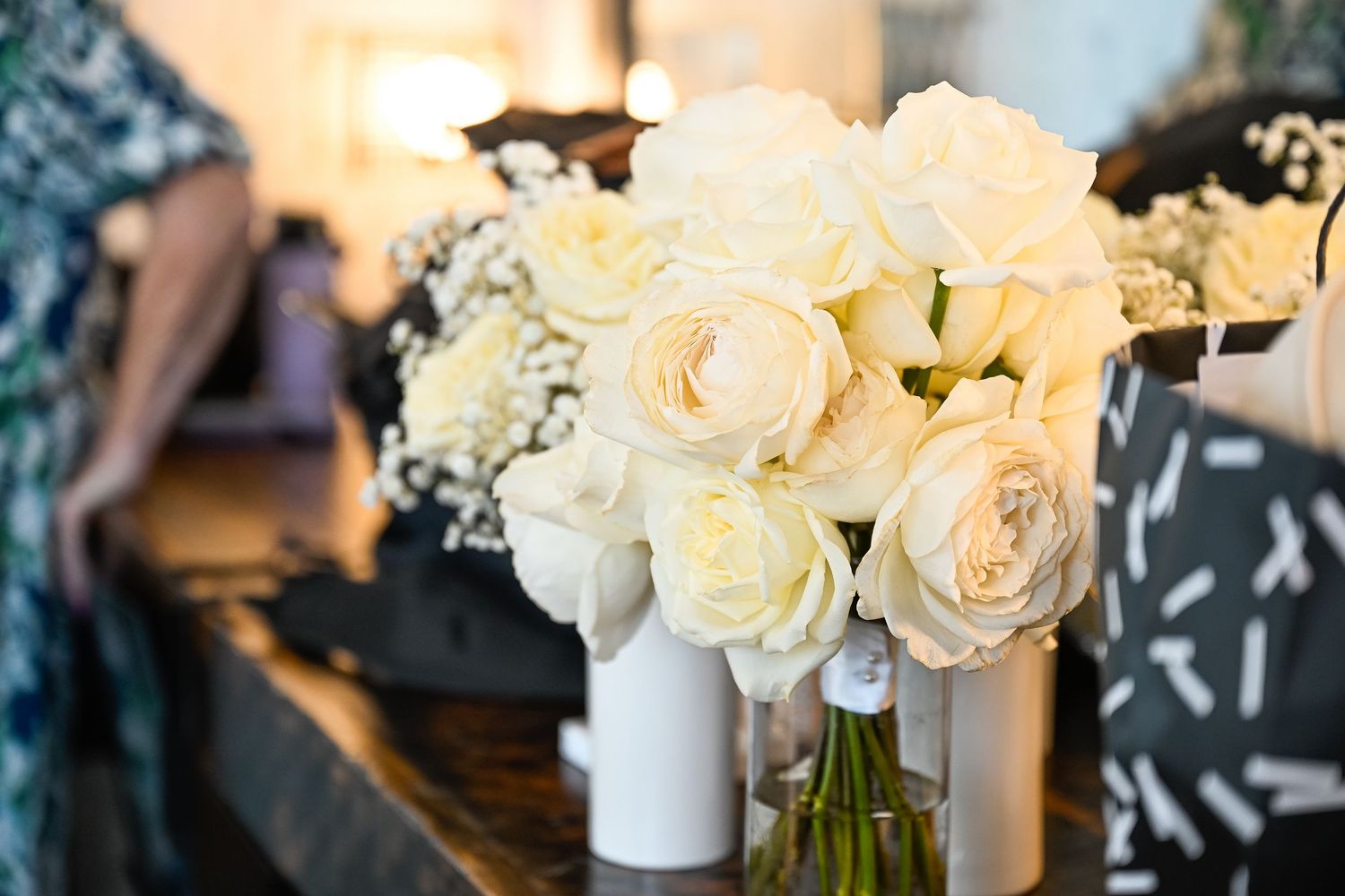 Elegant white roses in a vase arranged on a modern office table.